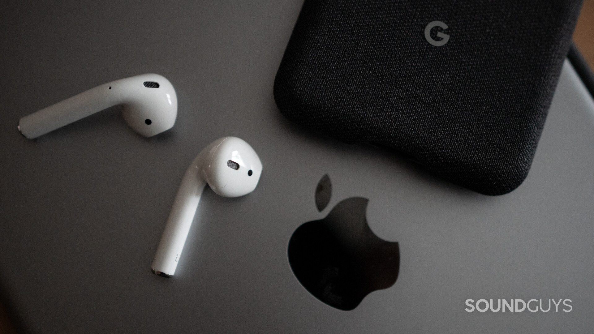 Airpods 2-4 The AirPods (2nd generation) on top of an iPad and next to the Google Pixel 3.