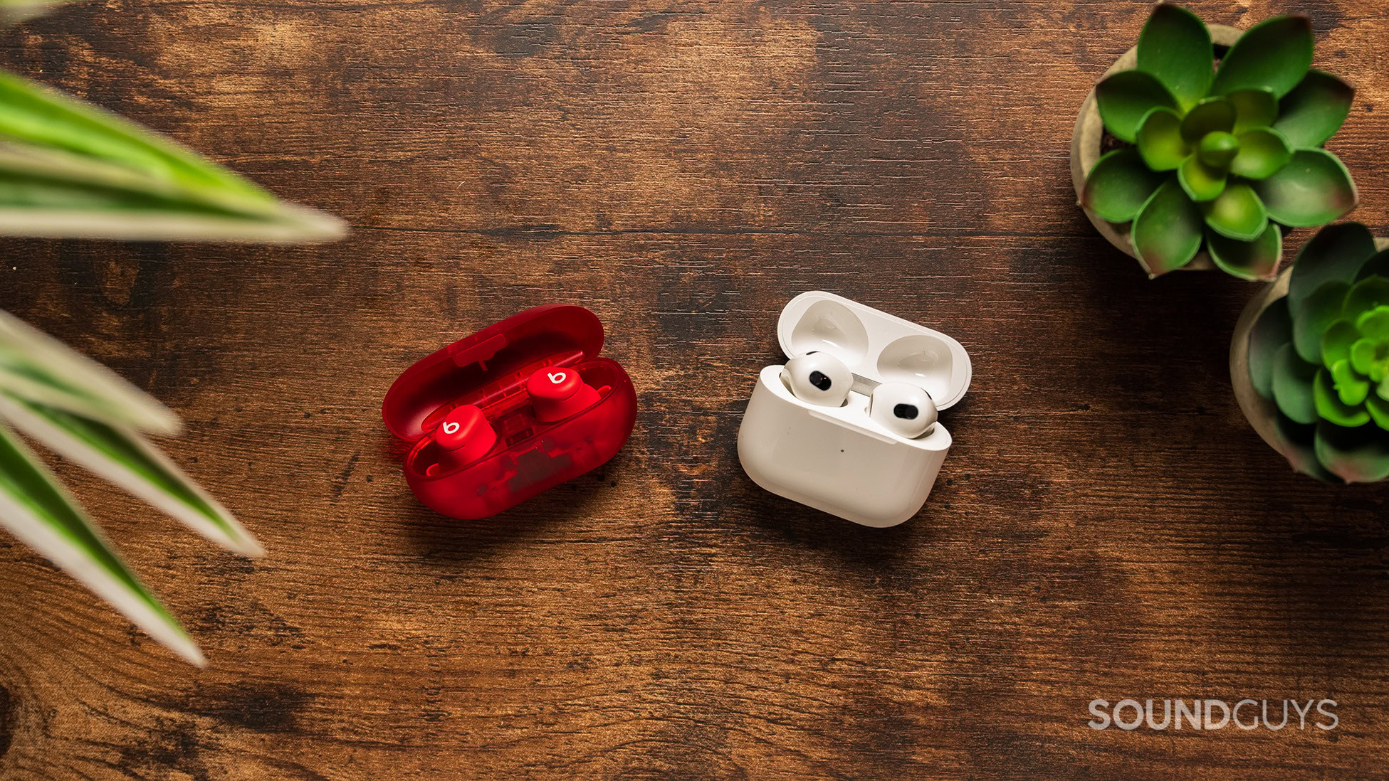Beats Solo Buds vs Apple AirPods (3rd generation) Beats Solo Buds on a table next to the Apple AirPods (3rd generation).