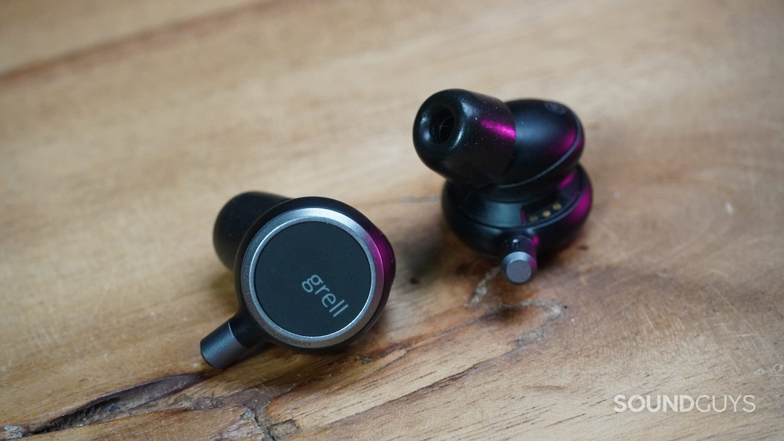 Grell Audio TWS 1 earbuds on table Grell Audio TWS 1 earbuds laying on a wood table