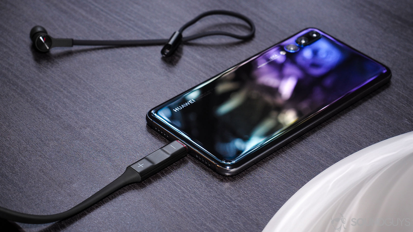 Huawei_FreeLace-1-USB C phone A picture of the Huawei Freelace neckband earbuds right earbud detached from the neckband which is plugged into a Huawei P20 smartphone via the USB-C plug.