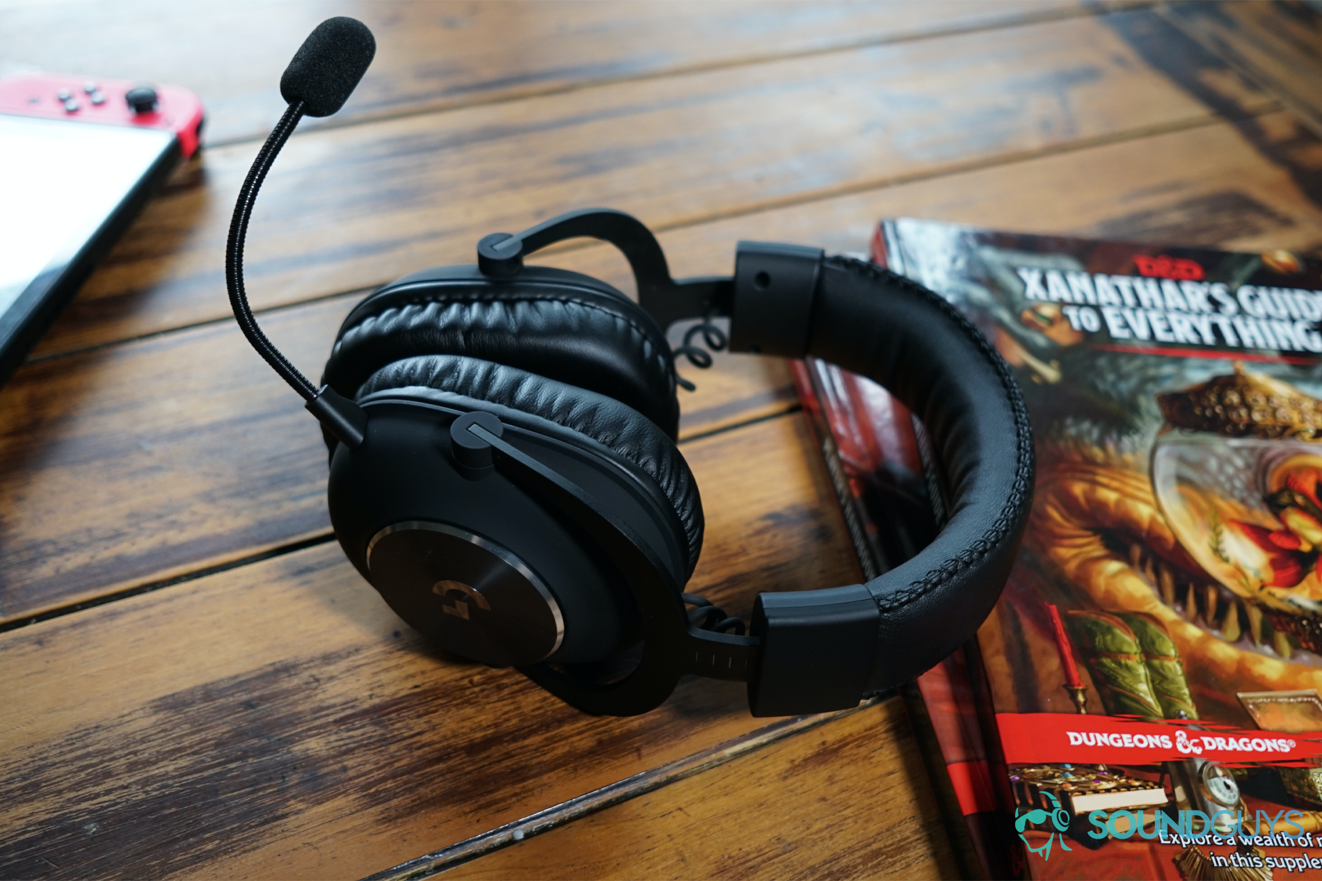 Logitech G Pro X dnd The Logitech G Pro X gaming headset leaning on Xanathar's Guide to Everything and the Dungeons and Dragons Players Handbook with a Nintendo Switch in the background.