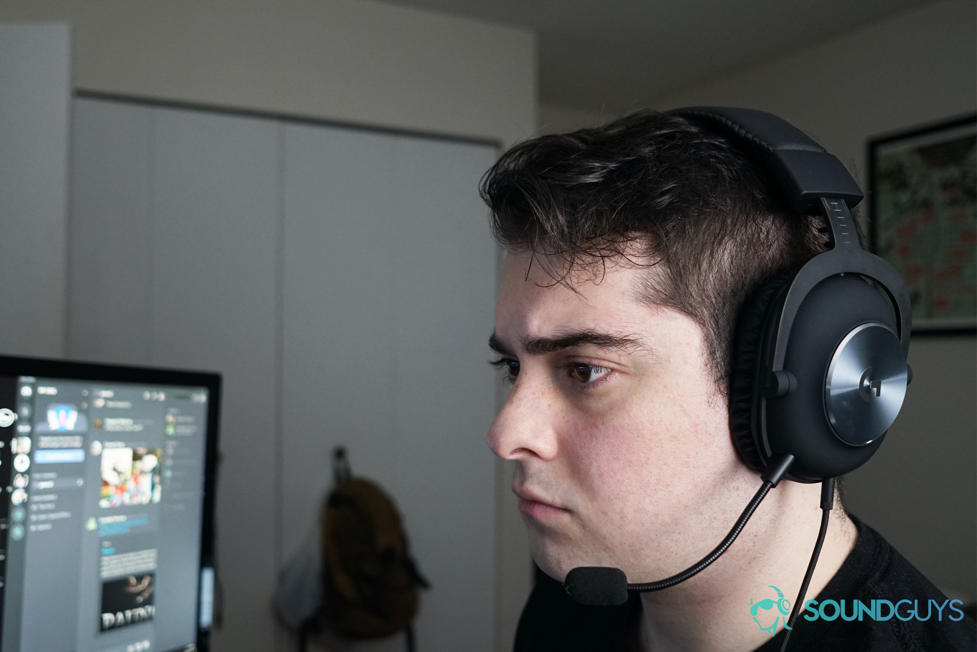 Logitech G Pro X headshot A man wears the Logitech G Pro X gaming headset sitting at a computer, with Discord running on a monitor behind him.