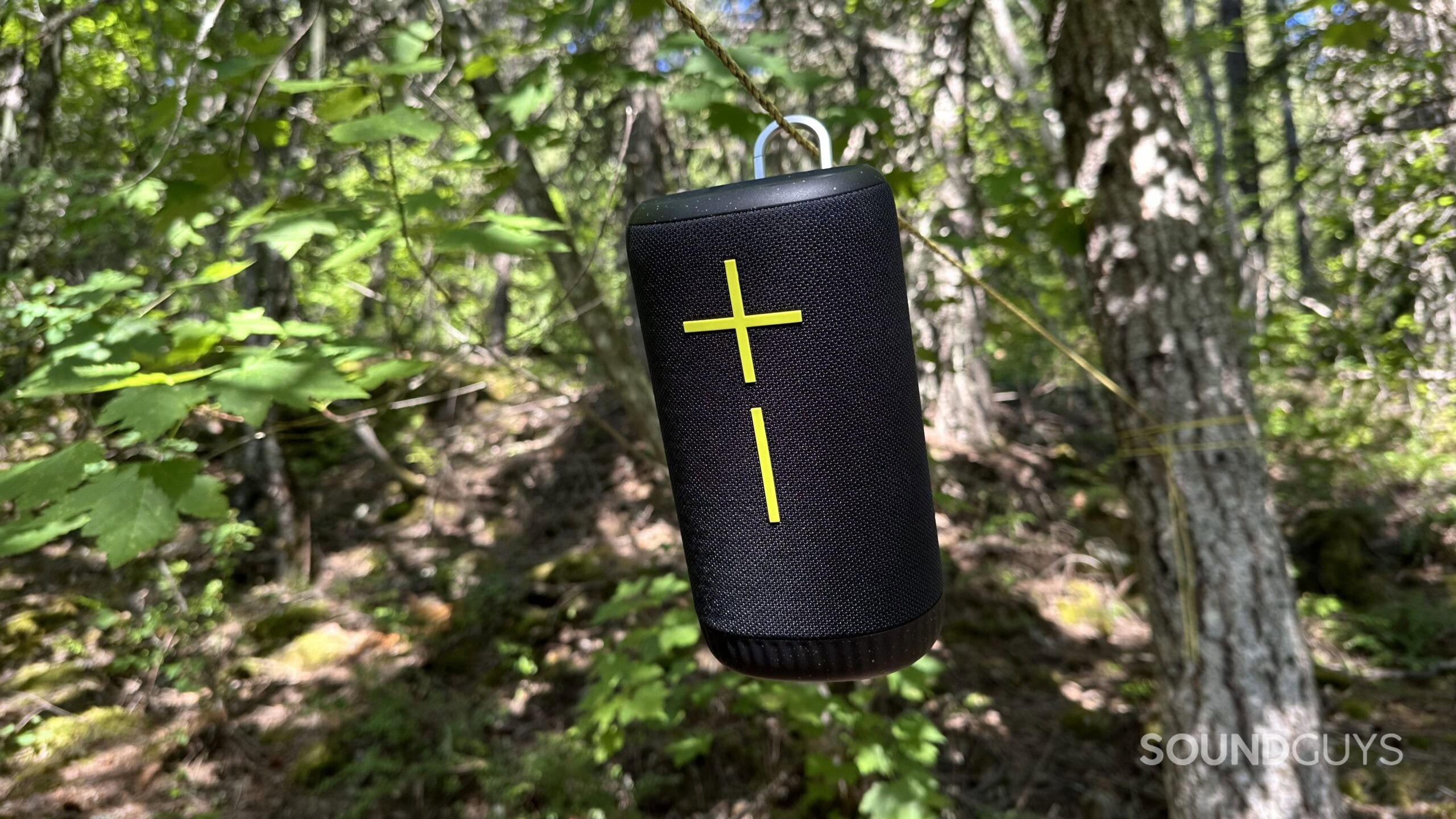 UE Everboom Hero A Ultimate Ears Everboom boom speaker clipped to a rope in a forest.